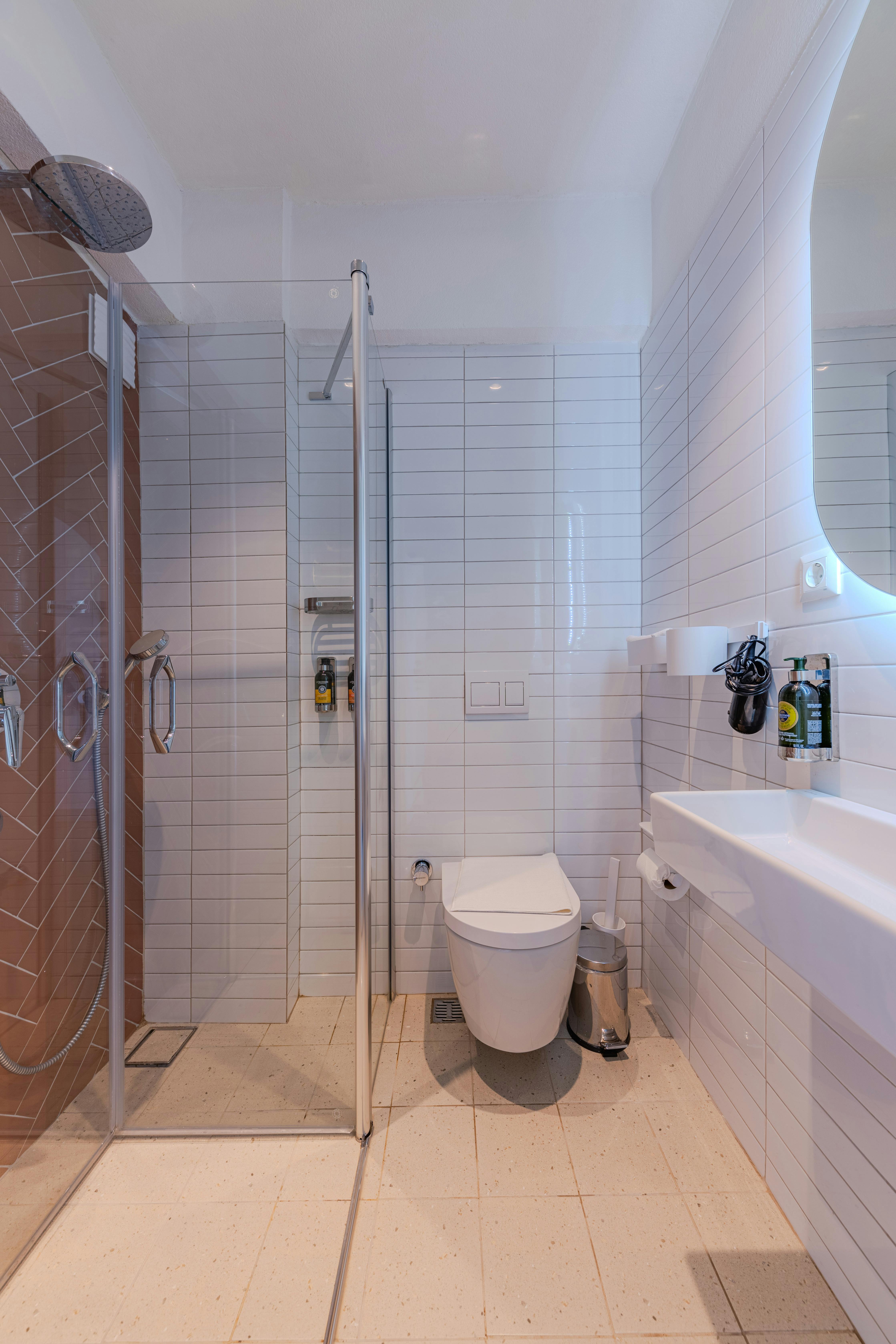 Tiled walk-in shower with clear glass enclosure and built-in niche