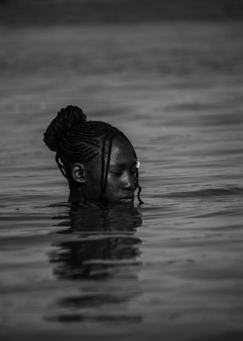 Free Black and white portrait of a woman floating peacefully in water. Reflective mood. Stock Photo