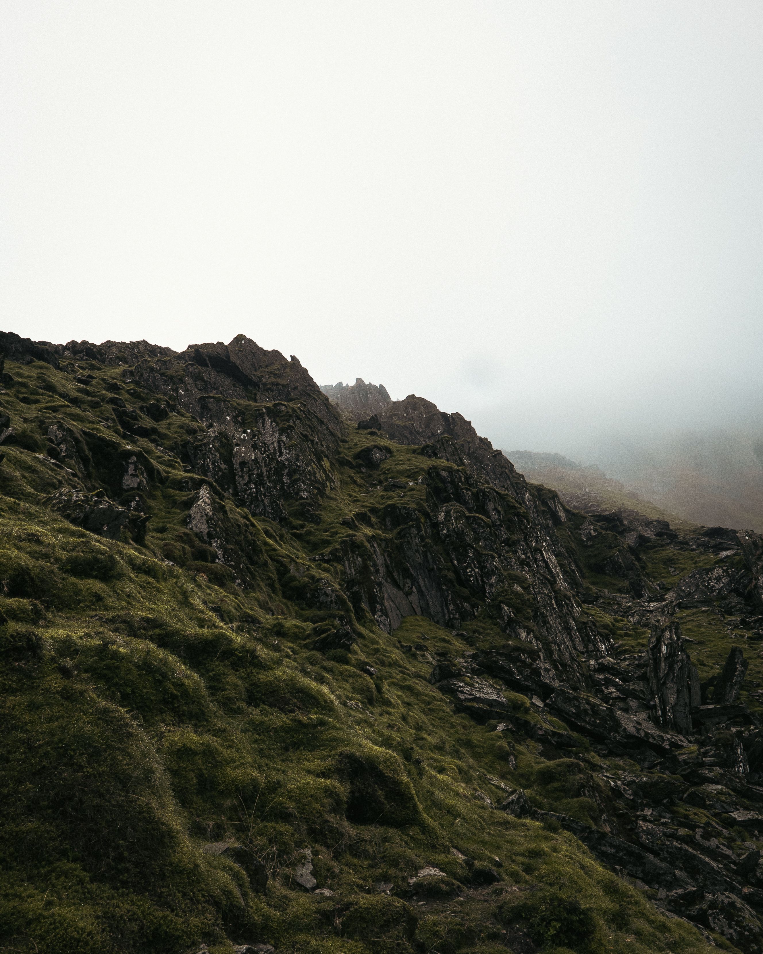 A serene view of misty mountains and rugged terrain in Lake District, UK.