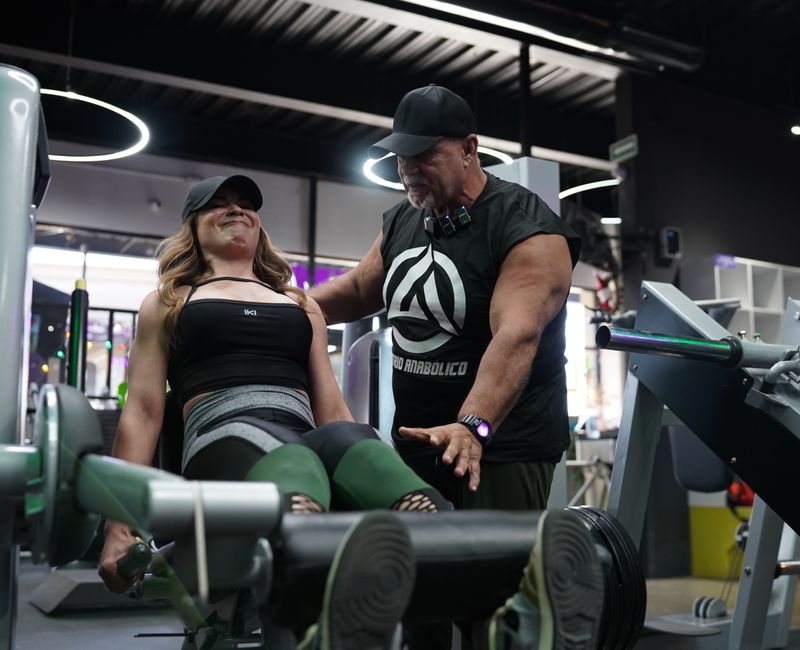 A personal trainer guiding a woman through strength exercises in a gym