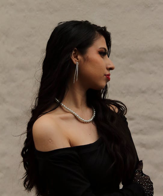 A timeless vintage-style portrait capturing elegance with a black dress and pearl necklace.