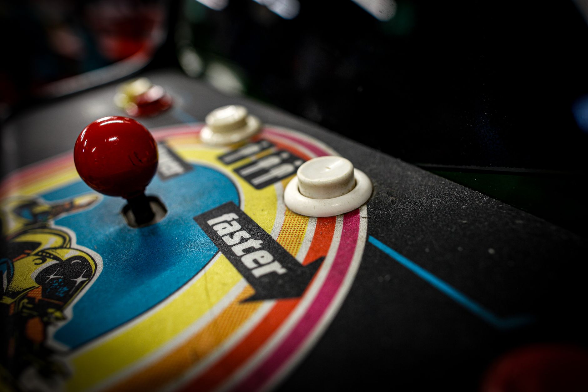 Close-up of a vintage arcade machine control panel with joystick and buttons.