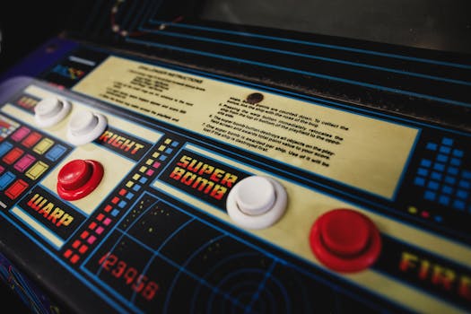 Close-up of a vintage arcade game control panel with colorful buttons and instructions.