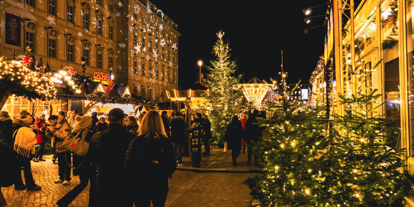 Illuminated wooden stalls at a European Christmas market in the evening