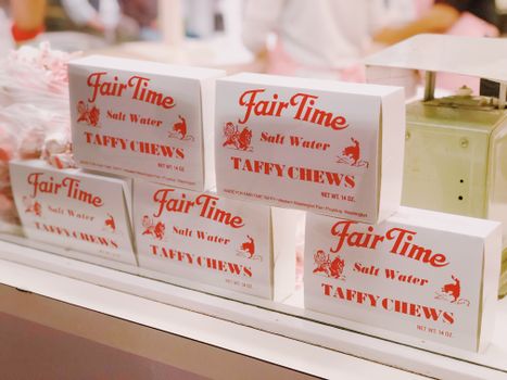 Five boxes of Fair Time Salt Water Taffy Chews on display in a candy store.