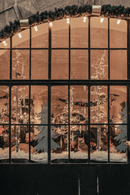 Free A warm indoor scene with Christmas decorations viewed through a window. Stock Photo