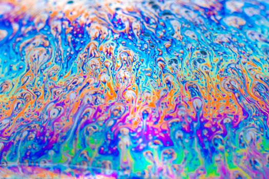 Colorful abstract pattern on a soap bubble with swirling vibrant hues.