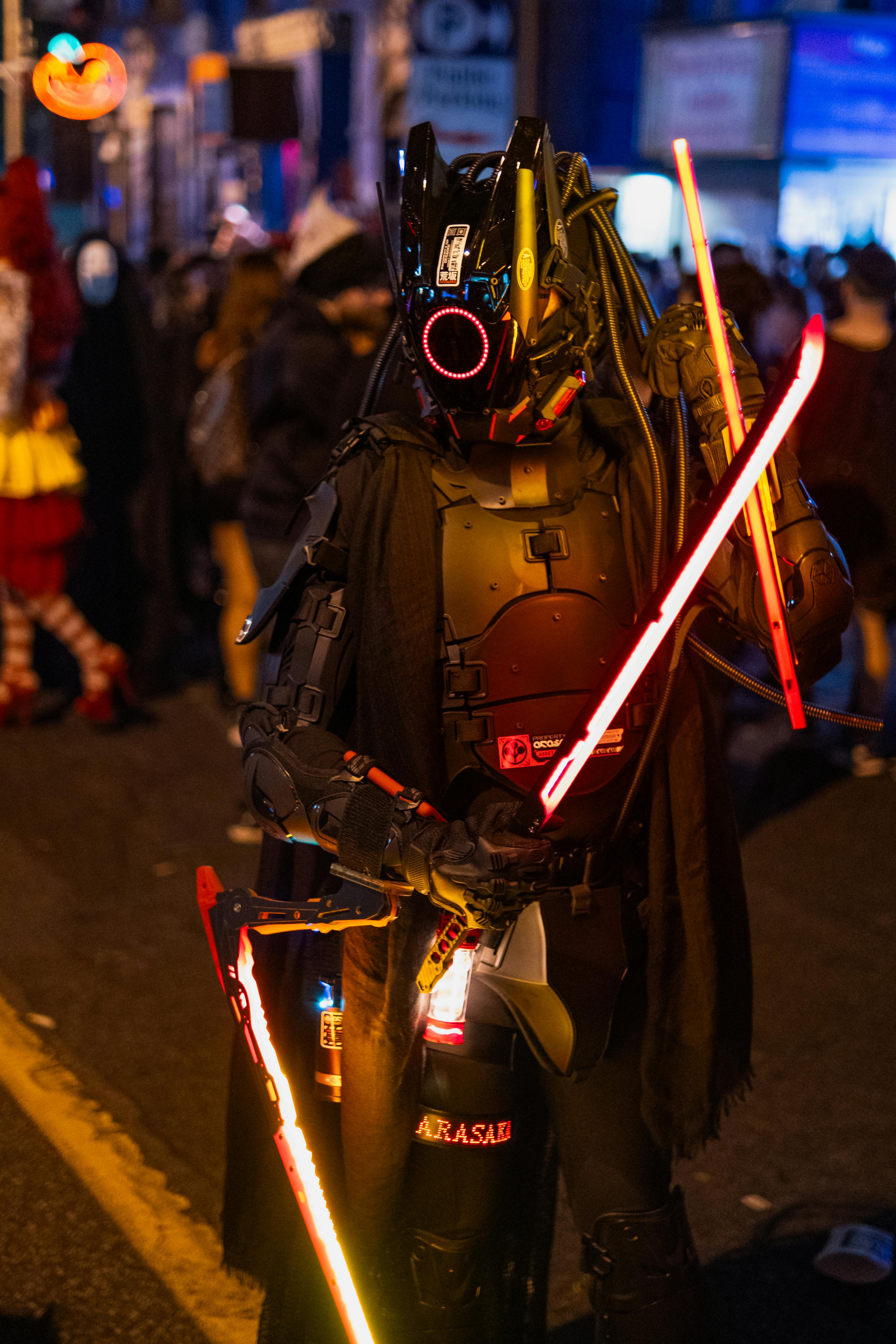 A person in a cyberpunk costume at a vibrant Halloween street event in Toronto.