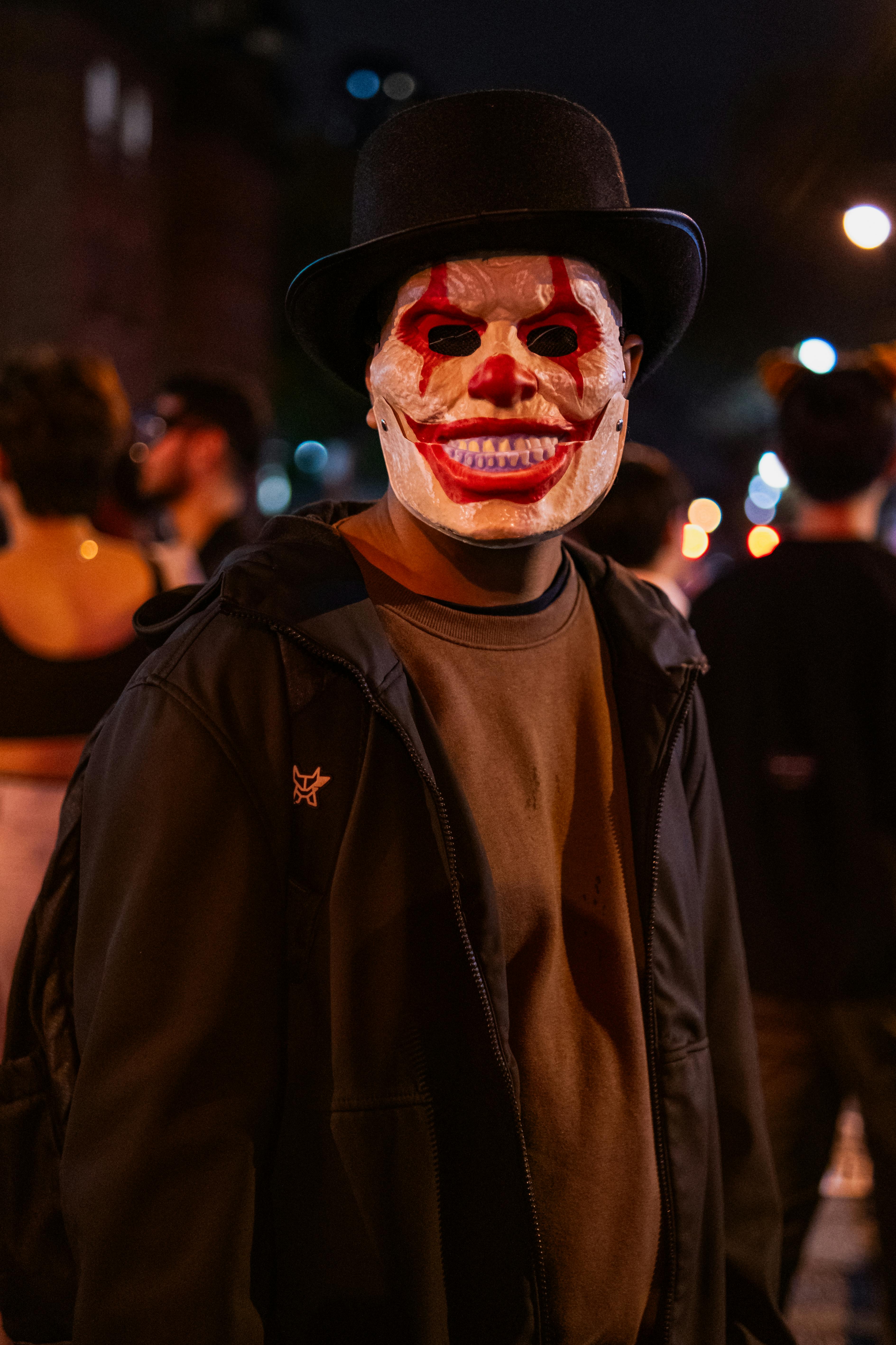 Portrait of a person in a clown mask during a Halloween street celebration in Toronto.