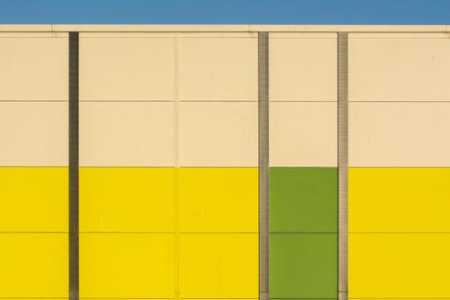Free Vibrant geometric building facade with bold colors and clear sky background. Stock Photo