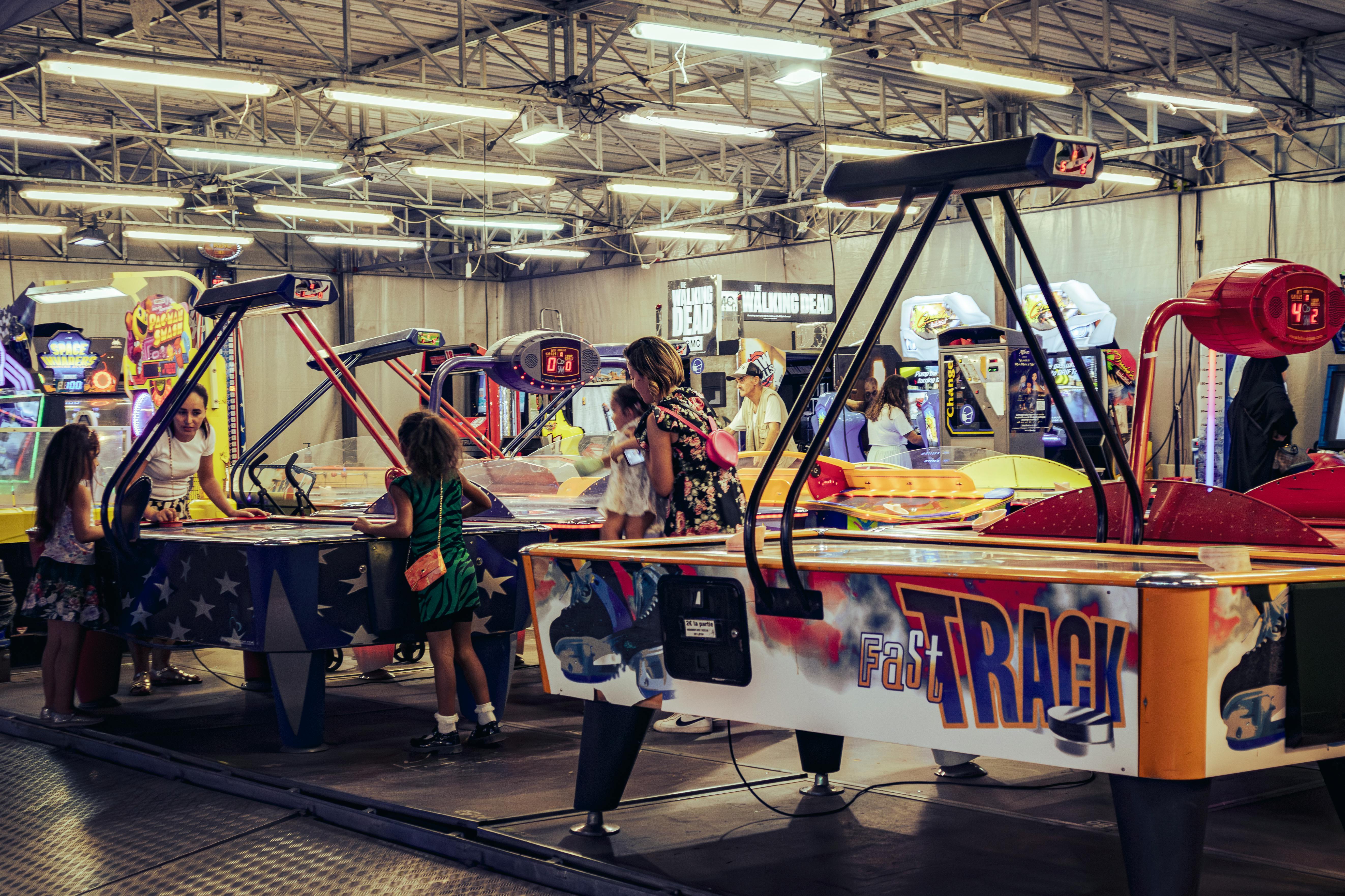 Row of colorful pinball machines with players at an arcade bar in Chicago - arcade bar chicago