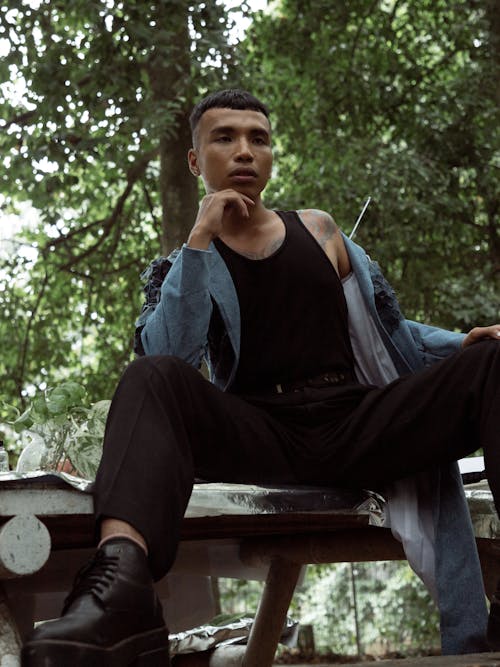 A Man Modeling while Sitting on a Table