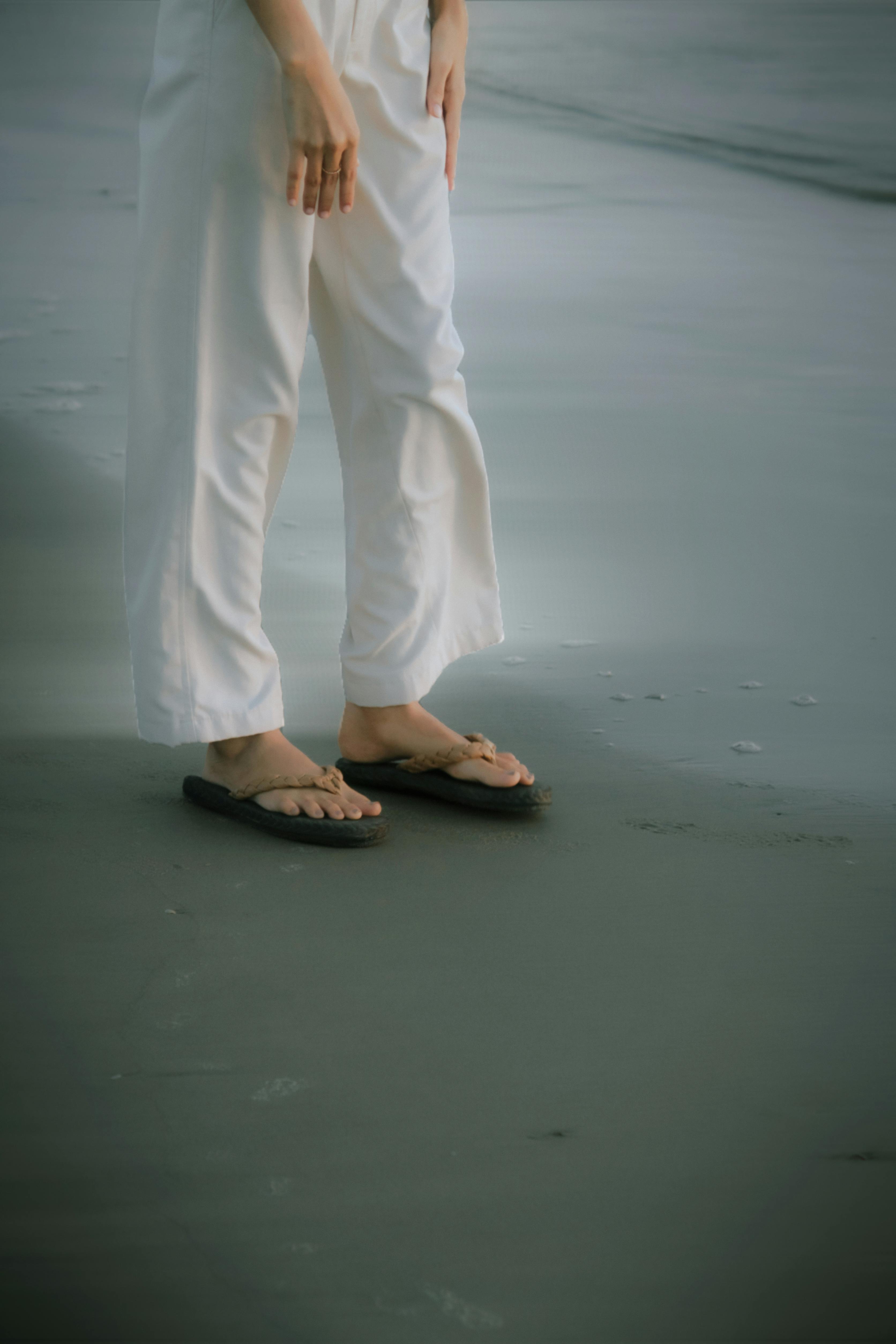 Casual attire with sandals on a sandy beach, perfect for a relaxing day by the sea.