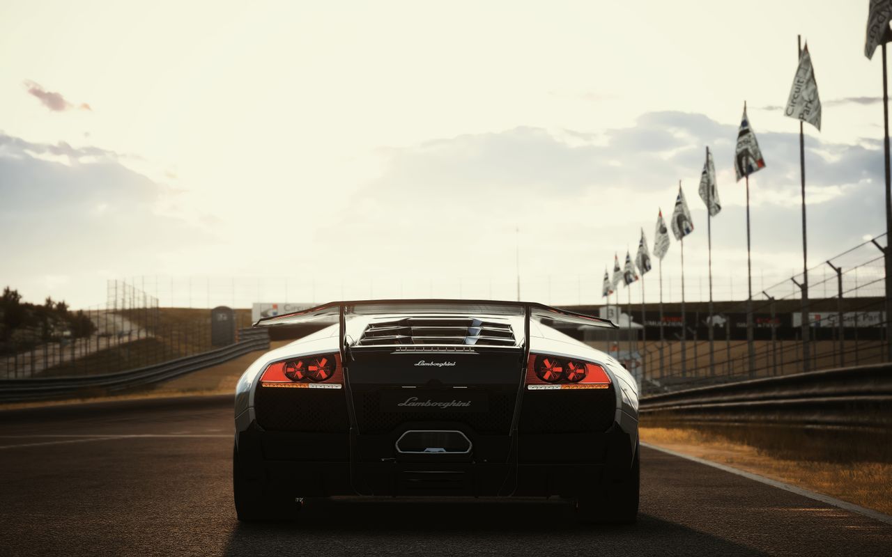 a sleek luxury sports car parked on a racetrack during sunset showcasi