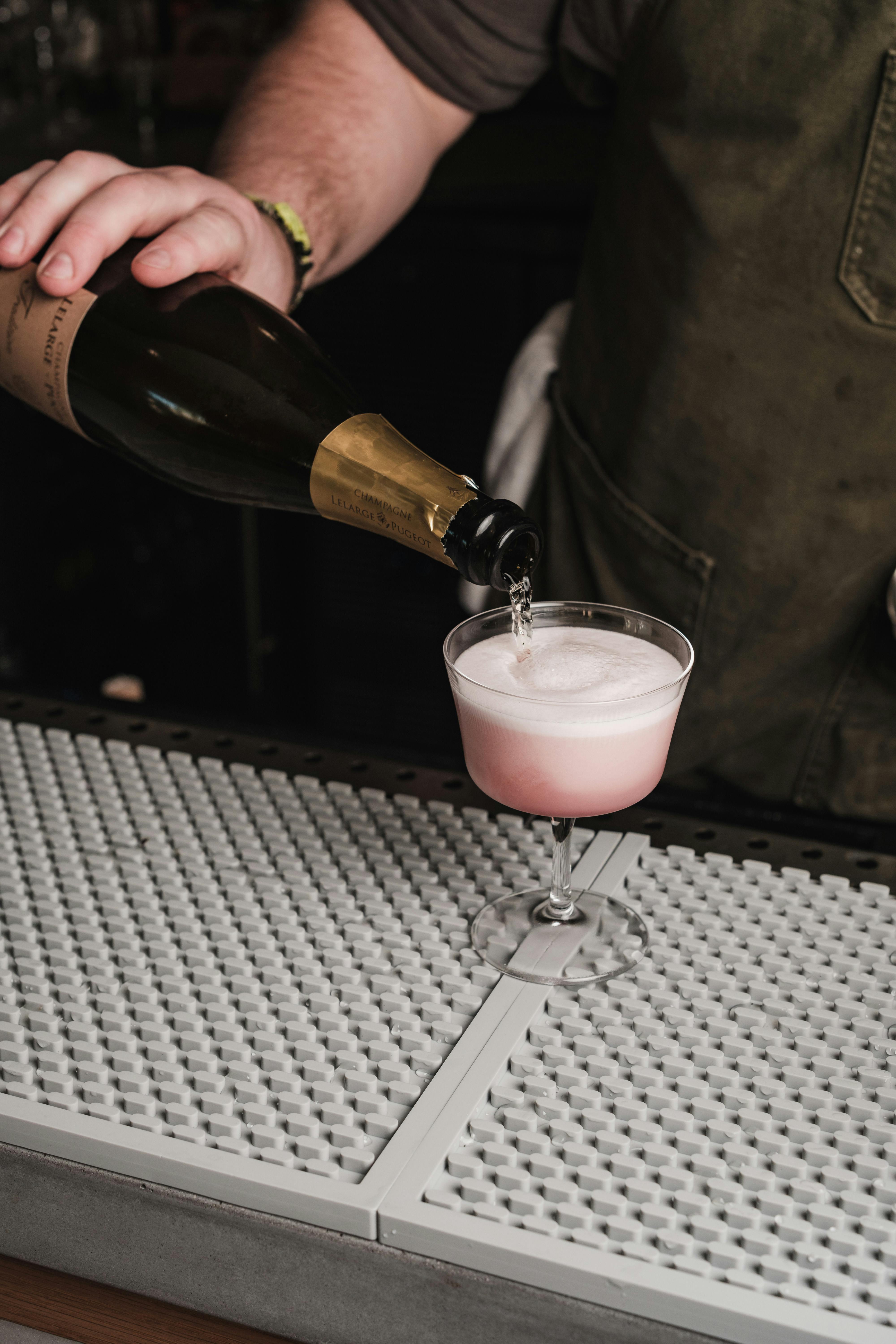 bartender pouring rose champagne into glass