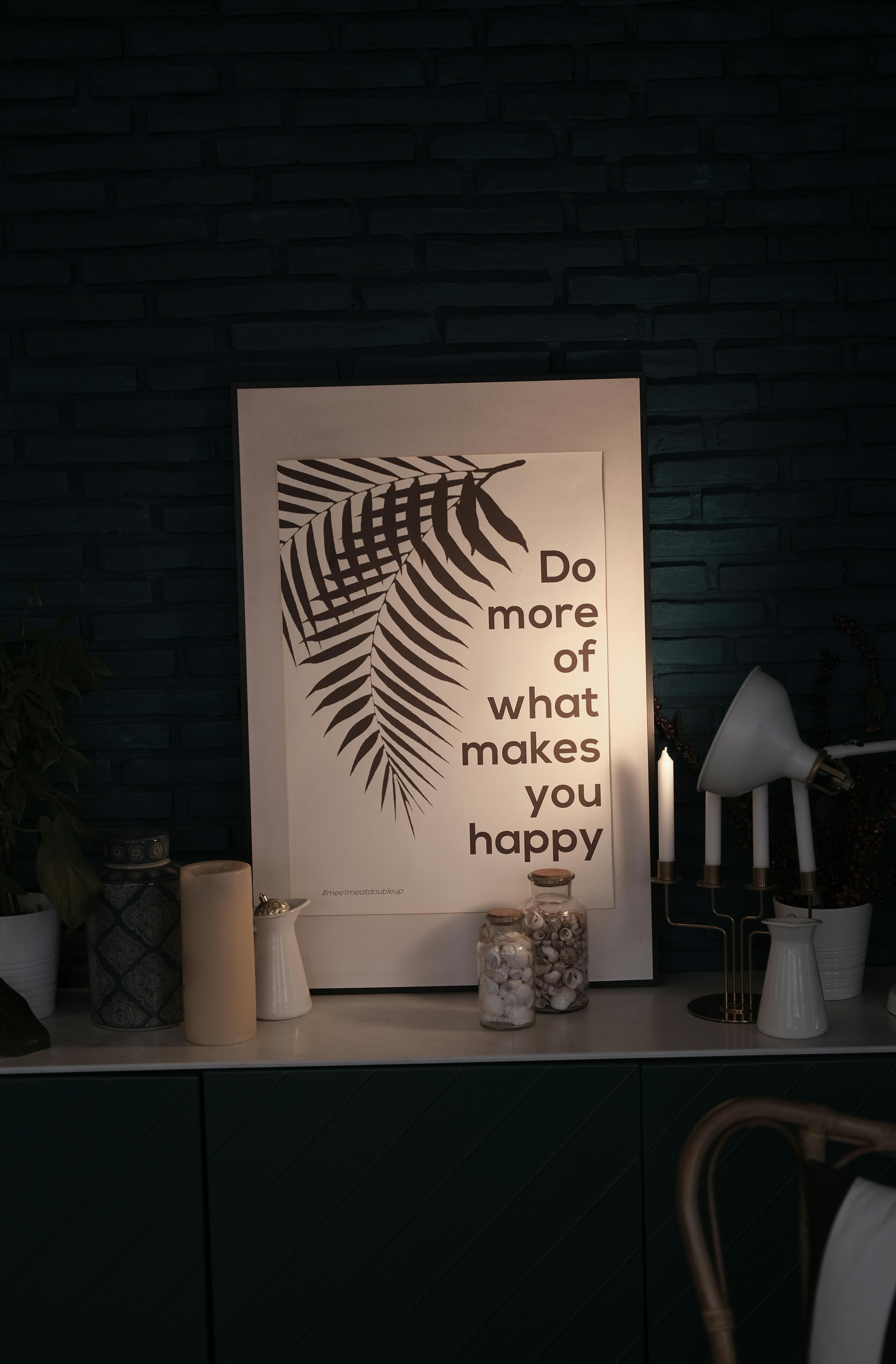 Gratuit Citat înrămat „Fă mai mult din ceea ce te face fericit” cu ilustrație de ferigă pe peretele întunecat. Fotografie de stoc