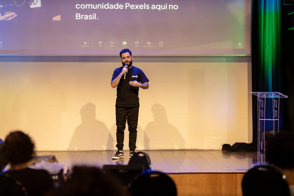 Man speaking on stage with a microphone at a conference in Brazil.