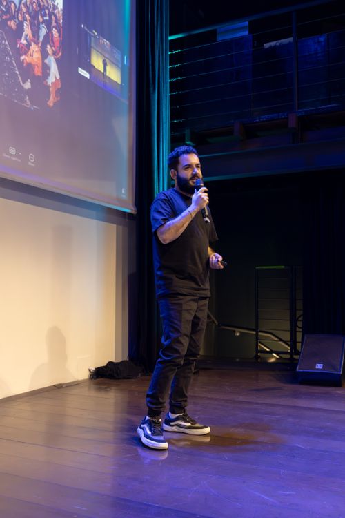 Free A man speaks confidently on stage with a microphone at an indoor conference. Stock Photo