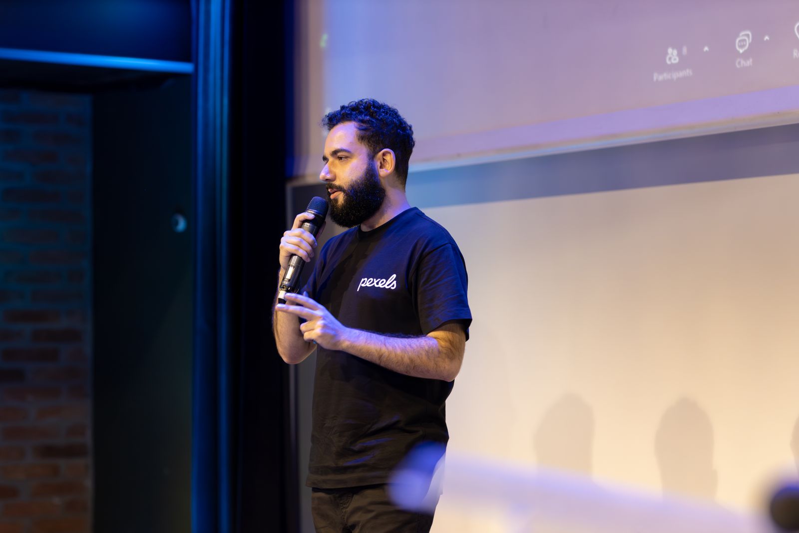 An event host speaking into a microphone in front of an audience
