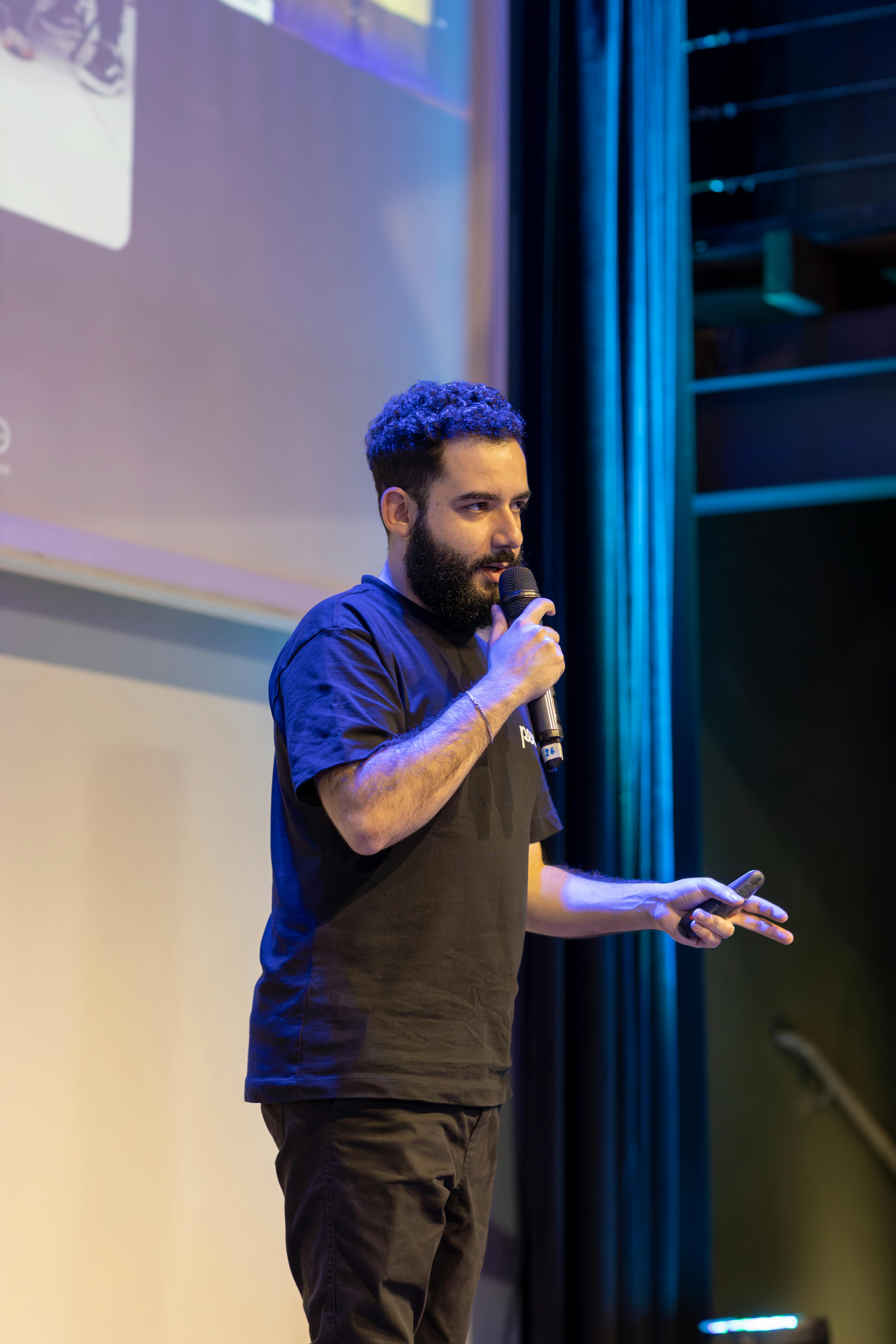 Speaker engaging audience during a live presentation in a theater setting.