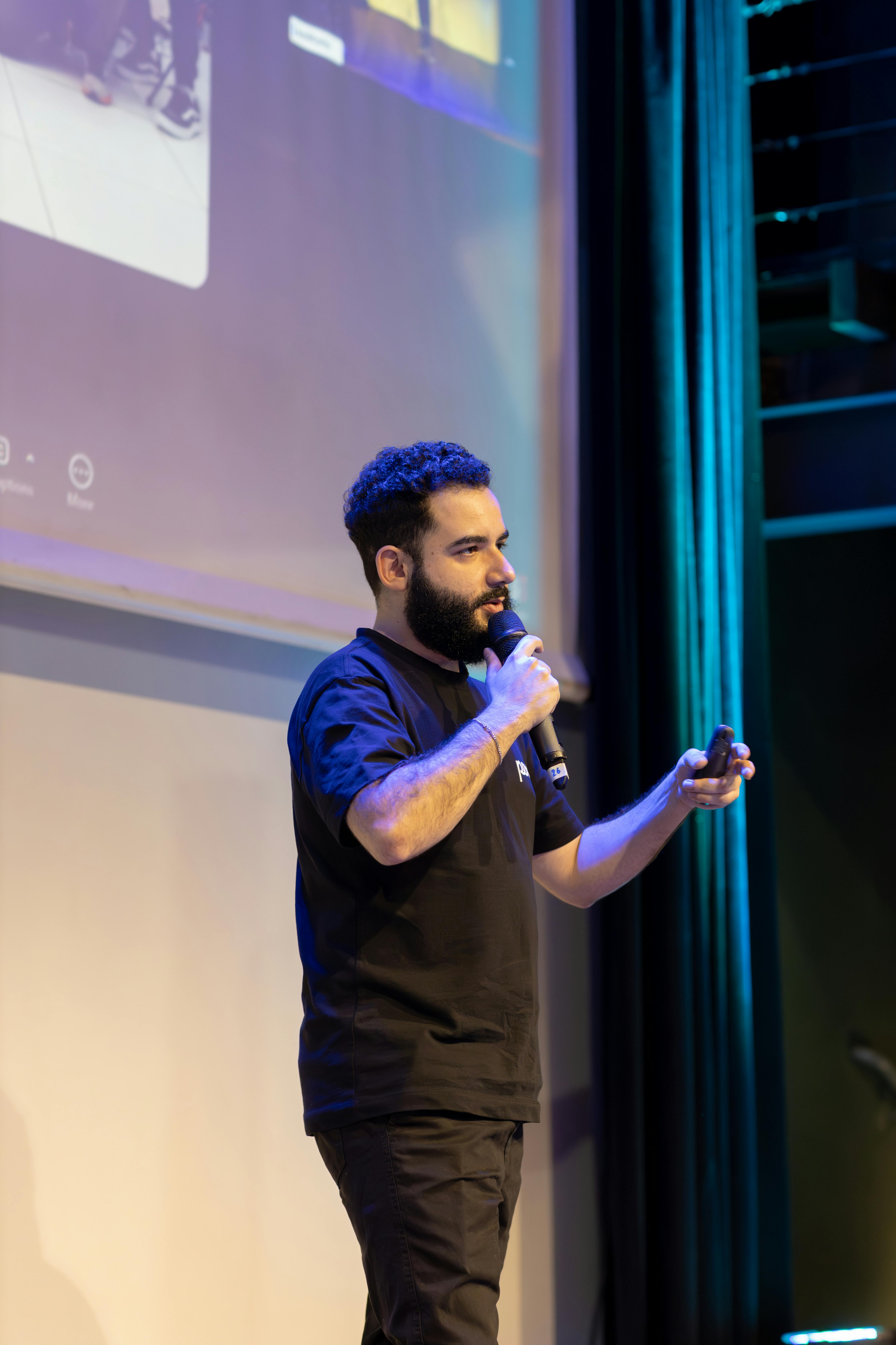 Ücretsiz Bir konferans etkinliğinde sahnede mikrofonla sunum yapan adam. Stok Fotoğraflar