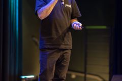 A man speaks confidently on stage, highlighting a professional presentation.