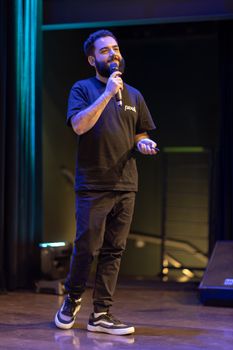 A man speaks confidently on stage, highlighting a professional presentation.