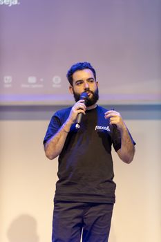 Man speaking into a microphone during a presentation indoors.
