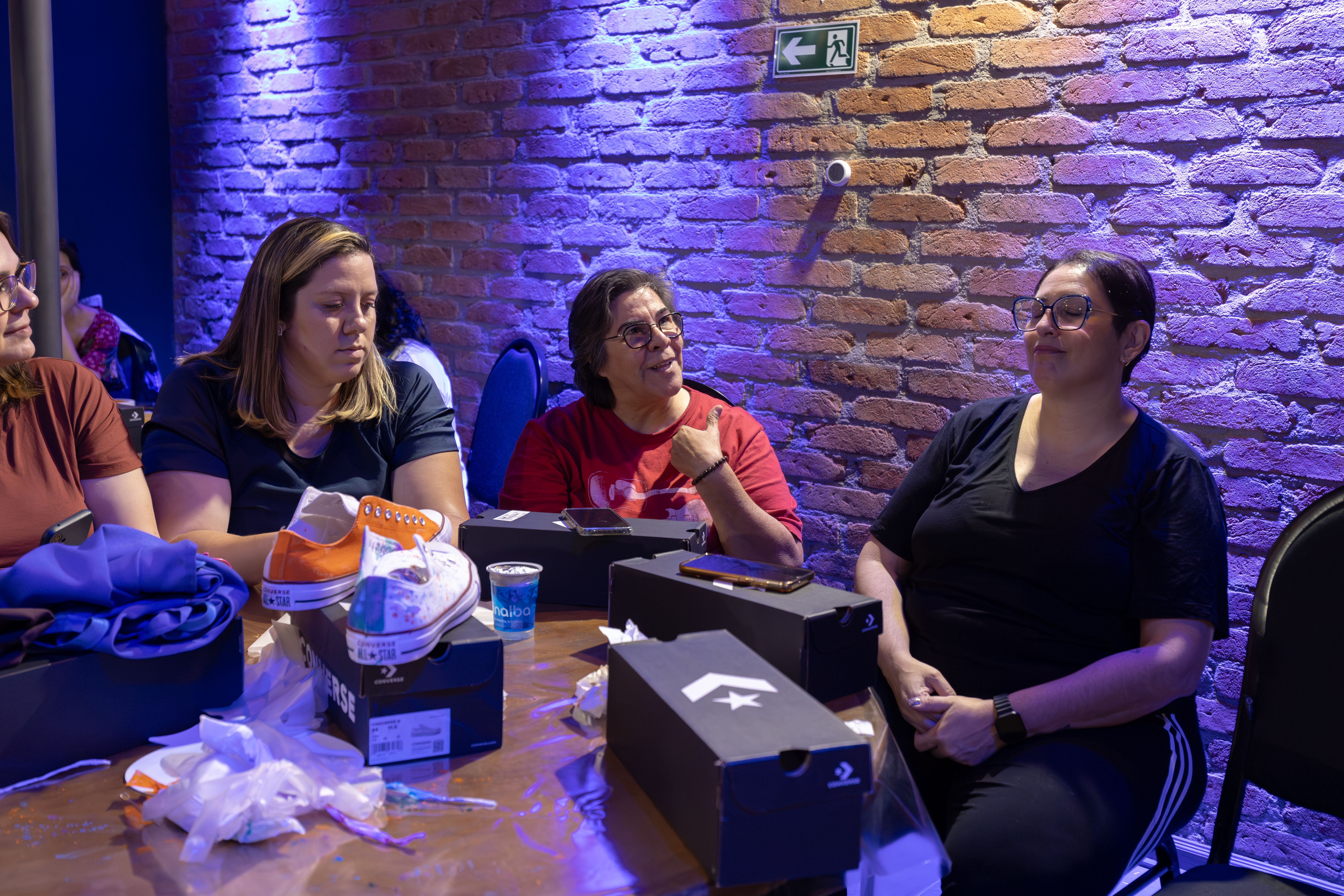 Group of women sharing Converse sneakers in a cozy indoor setting.
