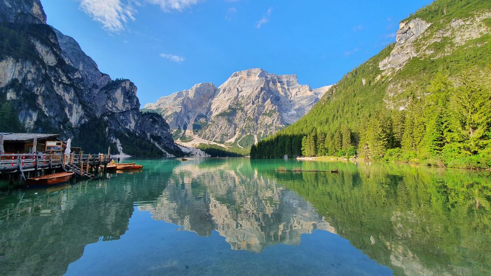 Reflexia perfectă a munților în apa nemișcată a Lacului Braies dimineața