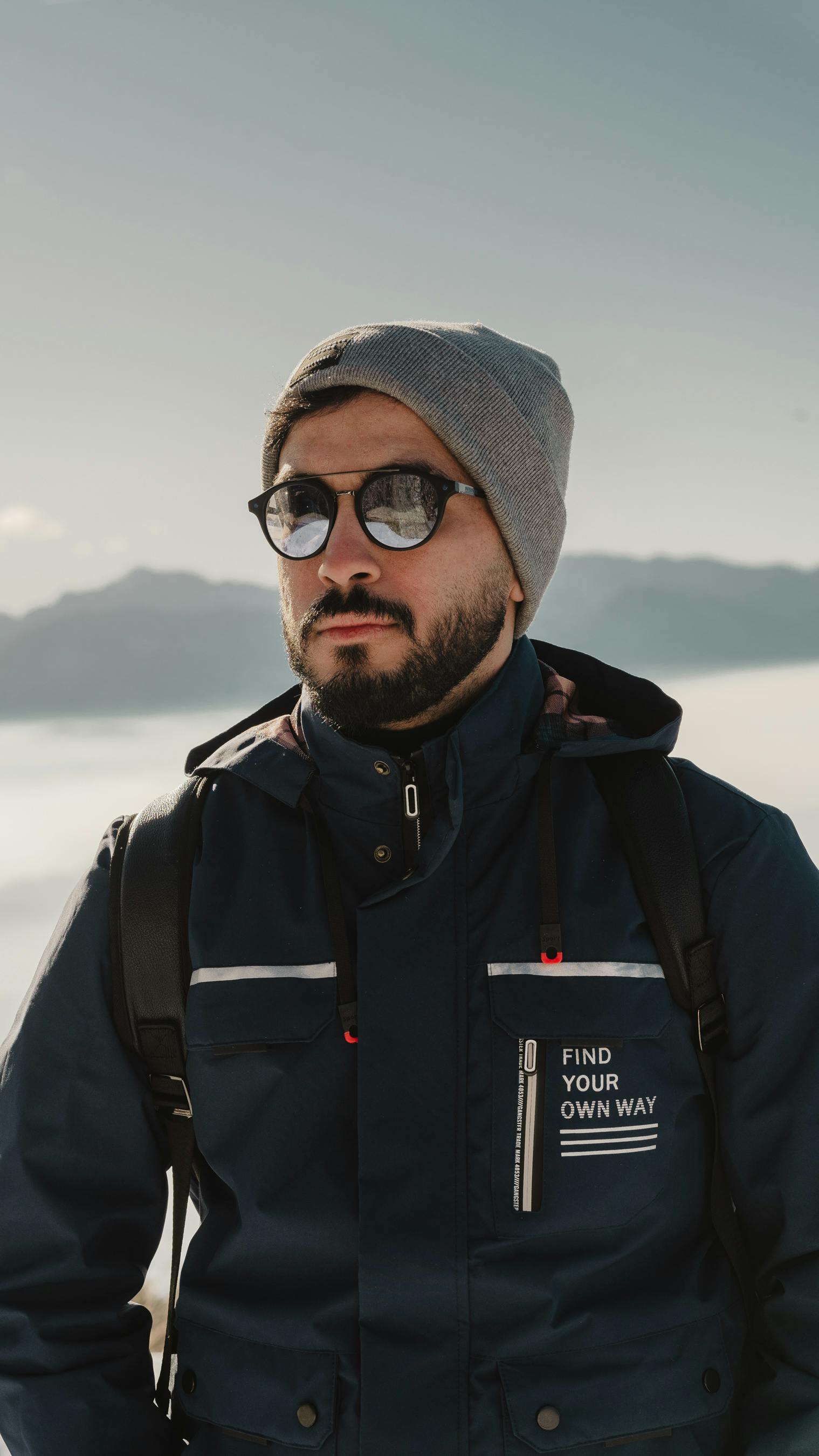 Man in sunglasses and winter jacket exploring snowy mountains in Carinthia, Austria.