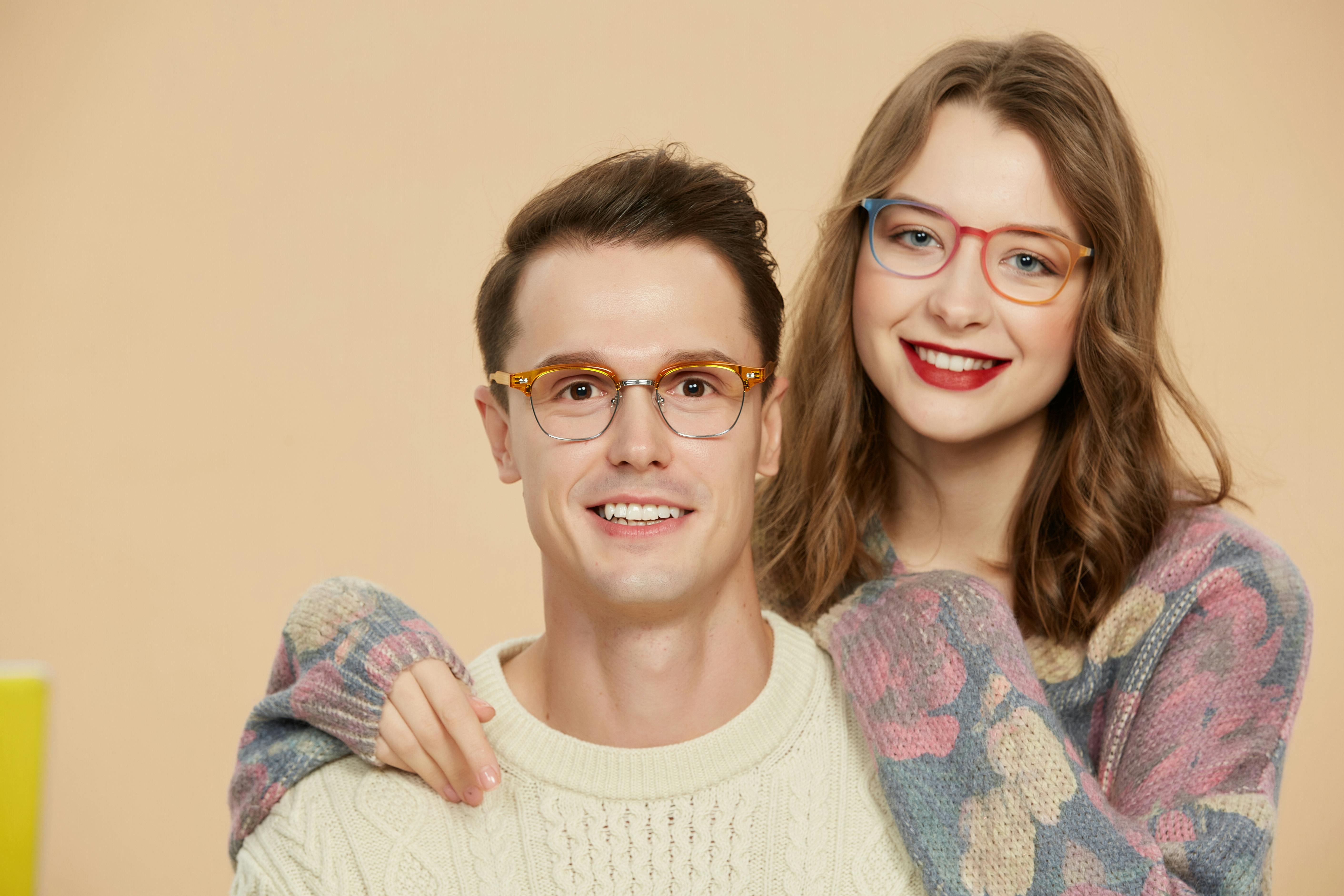 Gratis Una alegre pareja exhibiendo gafas modernas y suéteres acogedores en el interior. Foto de stock