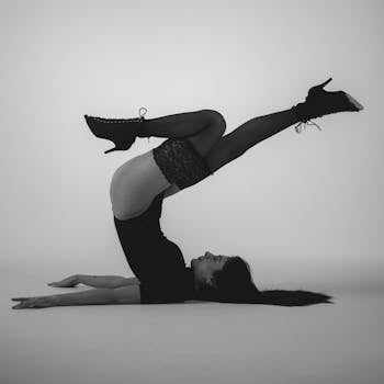 Artistic black and white photo of a woman in a contortion pose, showcasing elegance and strength.