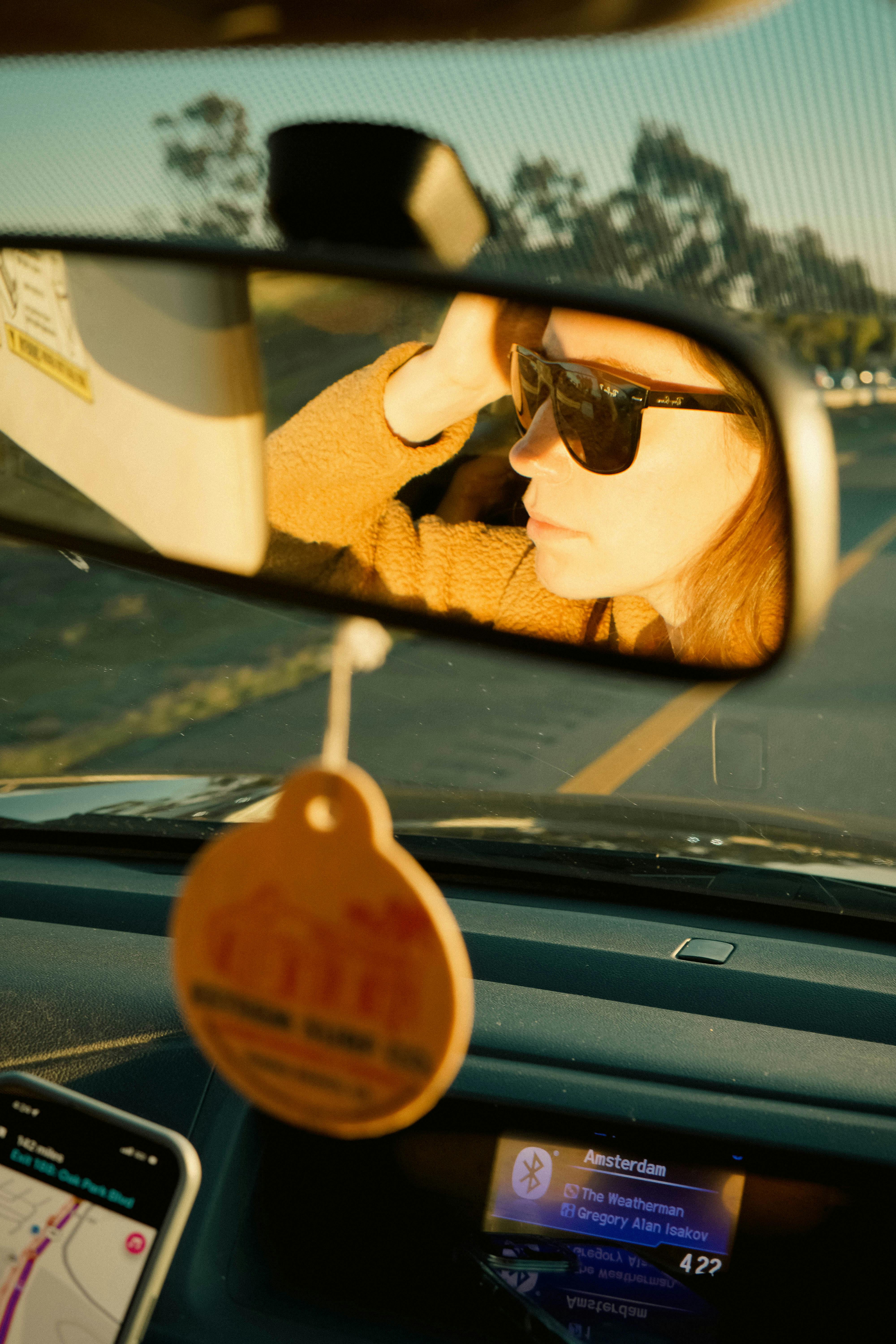 Capture the essence of a road trip with a rearview mirror reflection at sunset.