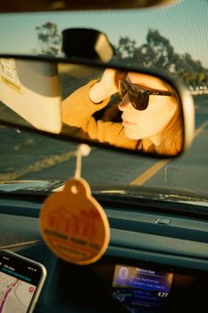 Capture the essence of a road trip with a rearview mirror reflection at sunset.