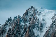 在晴朗的日光下，锯齿状的山峰覆盖着皑皑白雪，令人惊叹