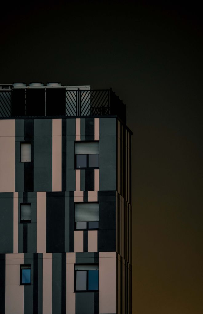 Modern building facade against a night sky. Photo by Francesco Ungaro on Pexels.