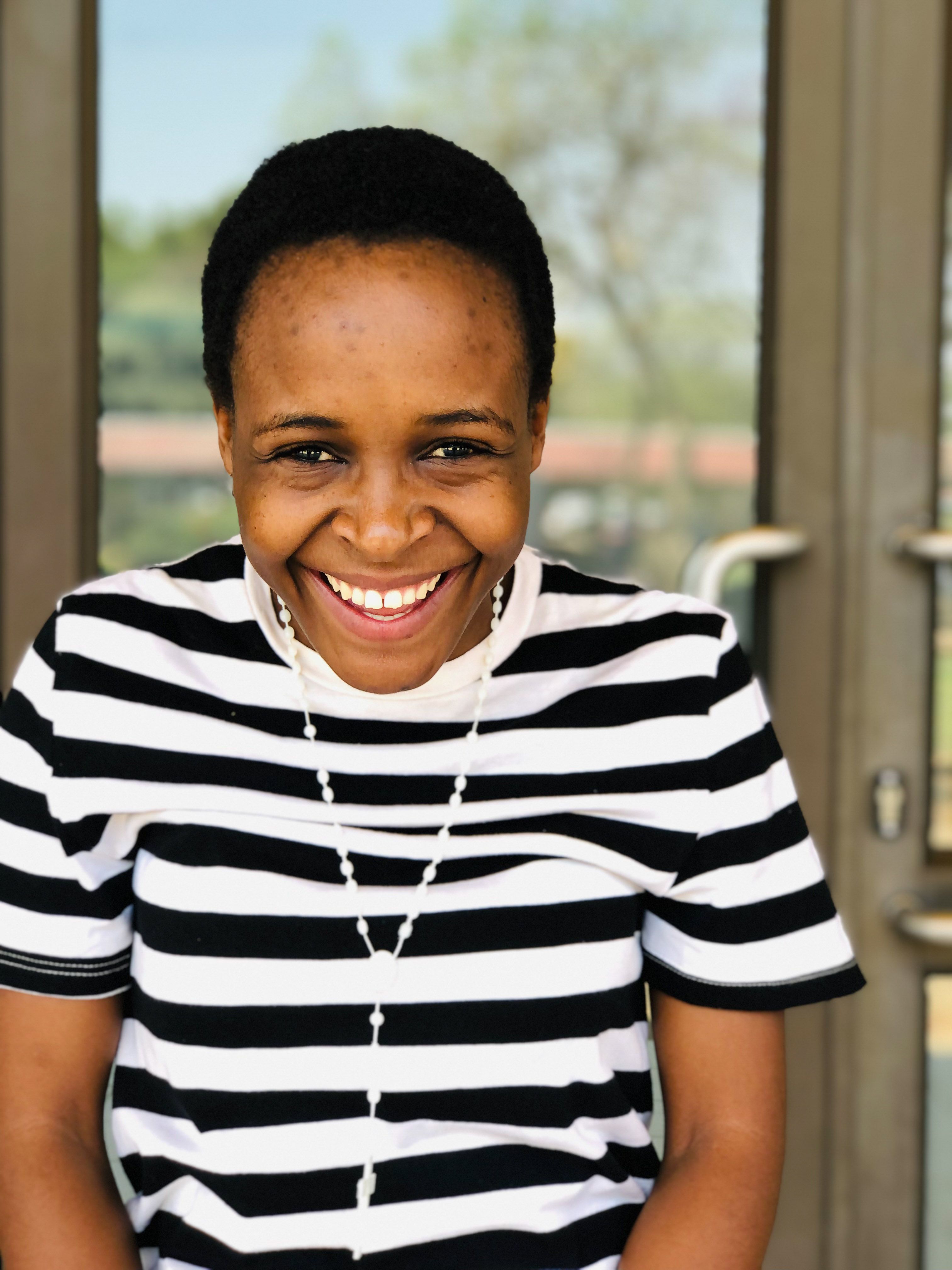 Smiling Woman in Striped Shirt Outdoors · Free Stock Photo