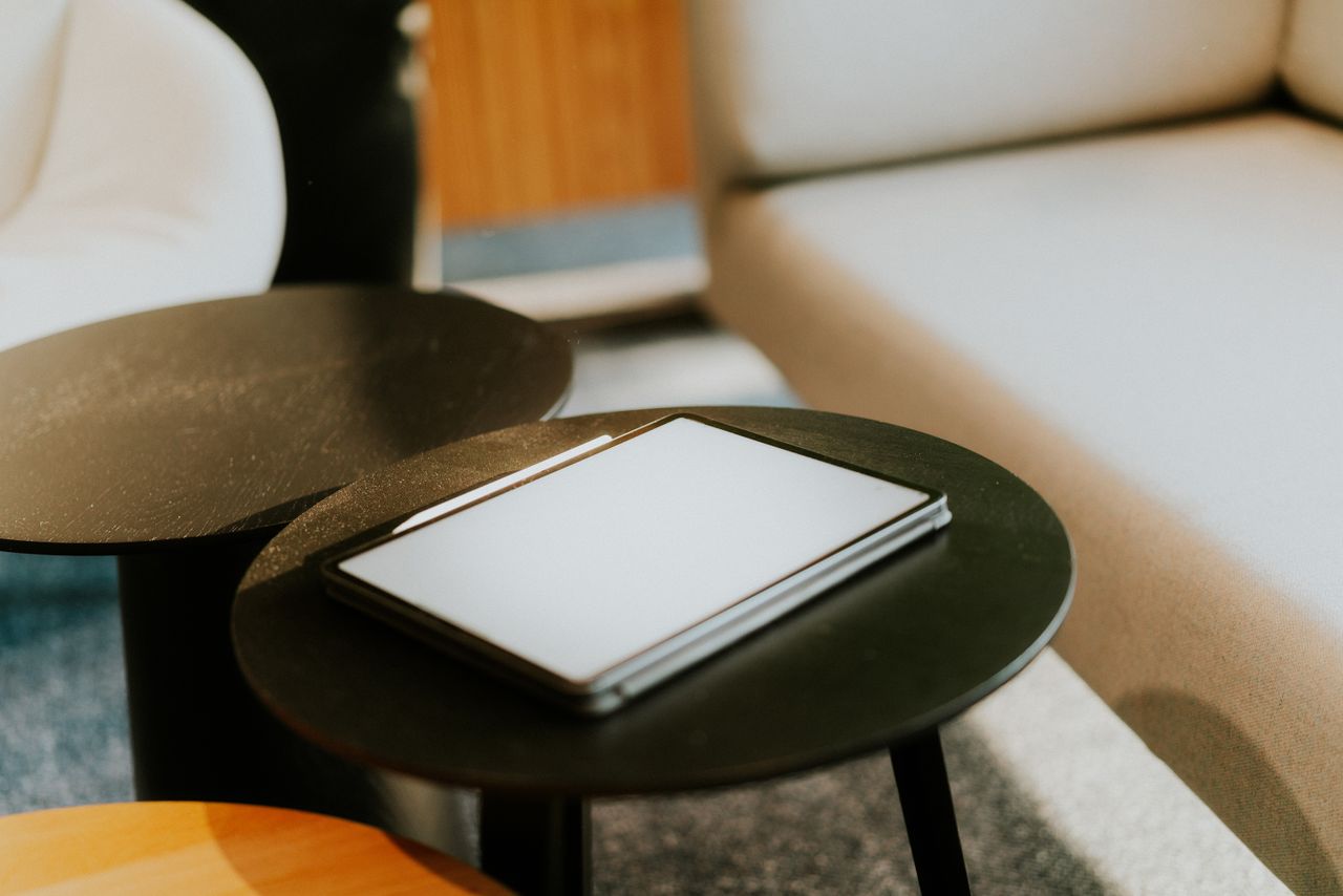 close up of a digital tablet on a black table in a cozy modern indoor