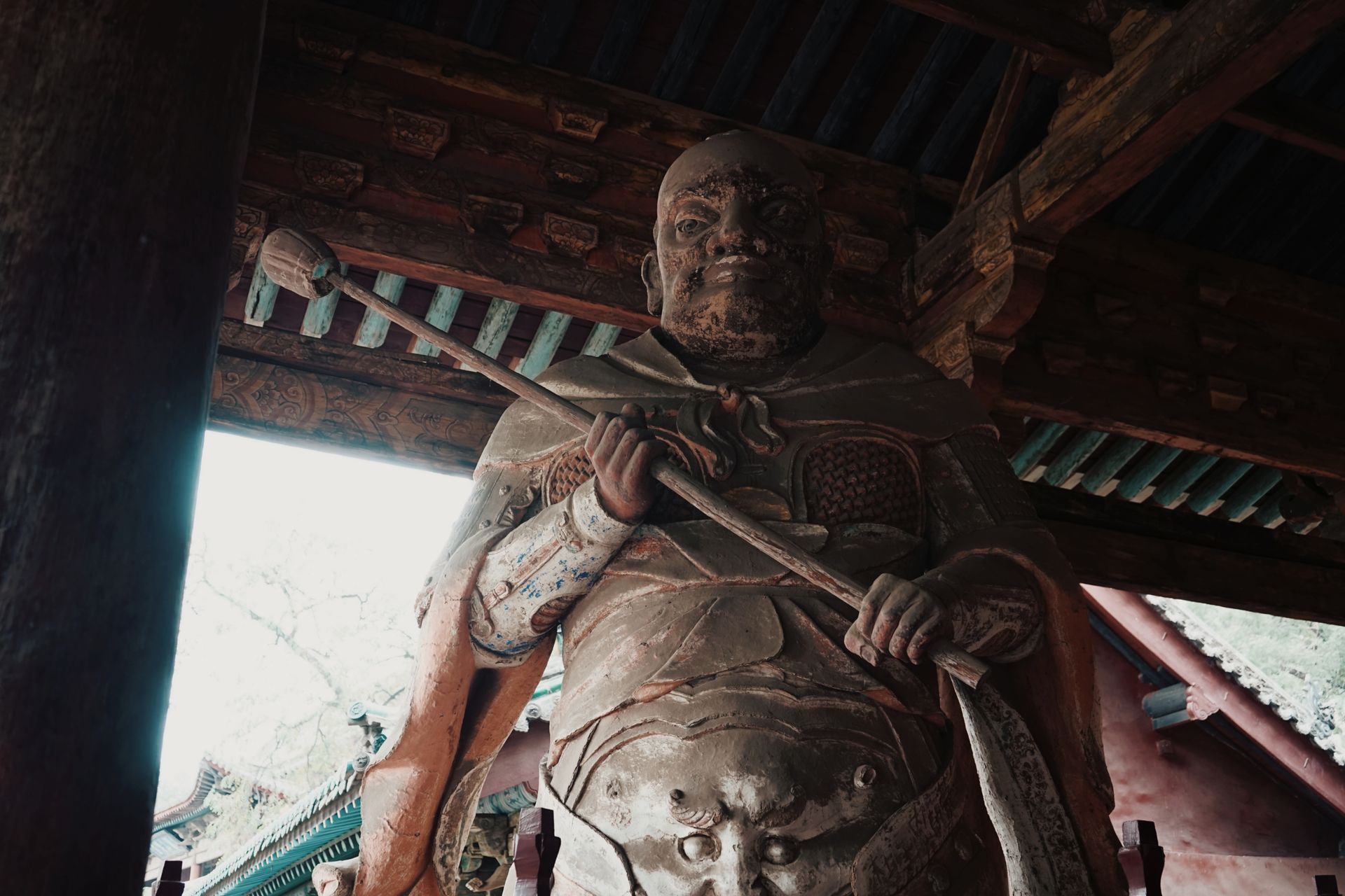 A detailed view of an ancient warrior statue in a historic Shanxi temple, showcasing cultural artistry.