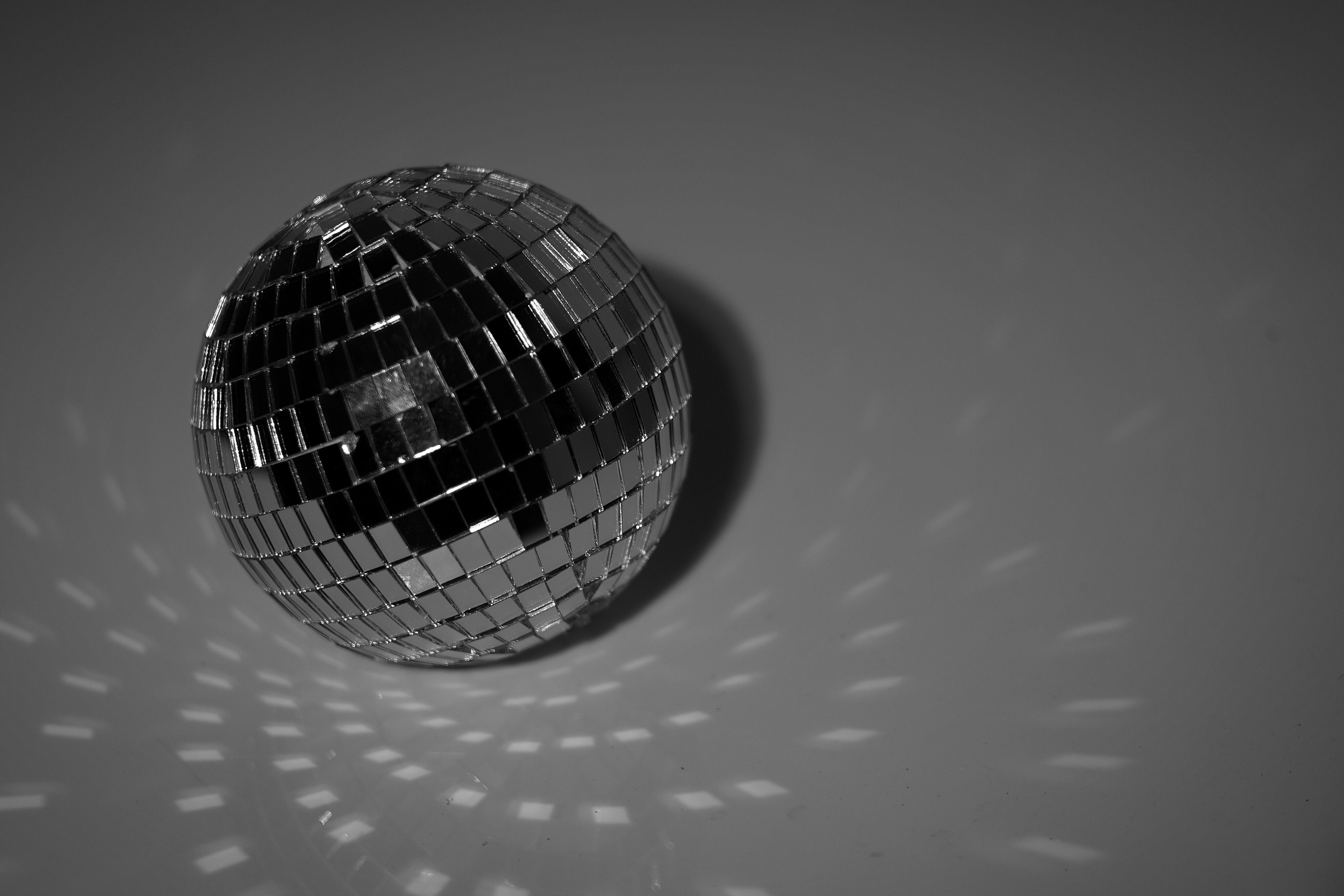 Black and white disco ball on a reflective surface for a silver theme