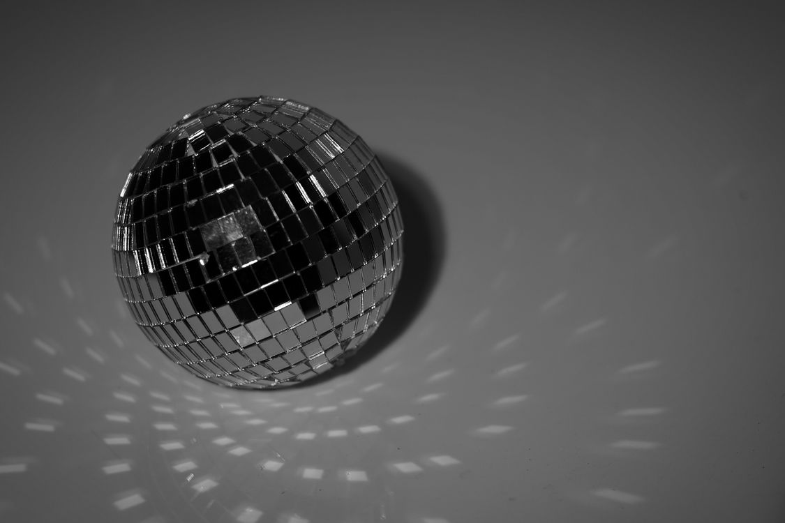 Black and white disco ball on a reflective surface for a silver theme
