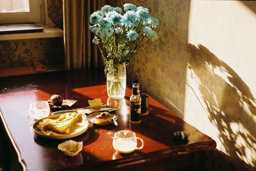 Free A bright and inviting kitchen scene with breakfast and a vase of flowers in natural light. Stock Photo