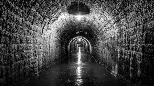 Free Explore the atmospheric stone-walled tunnel lit dimly for a dramatic effect. Stock Photo