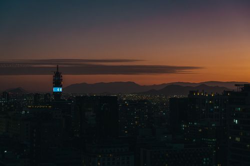 Free Stunning twilight view of Santiago's skyline with silhouetted skyscrapers and mountains in the horizon. Stock Photo