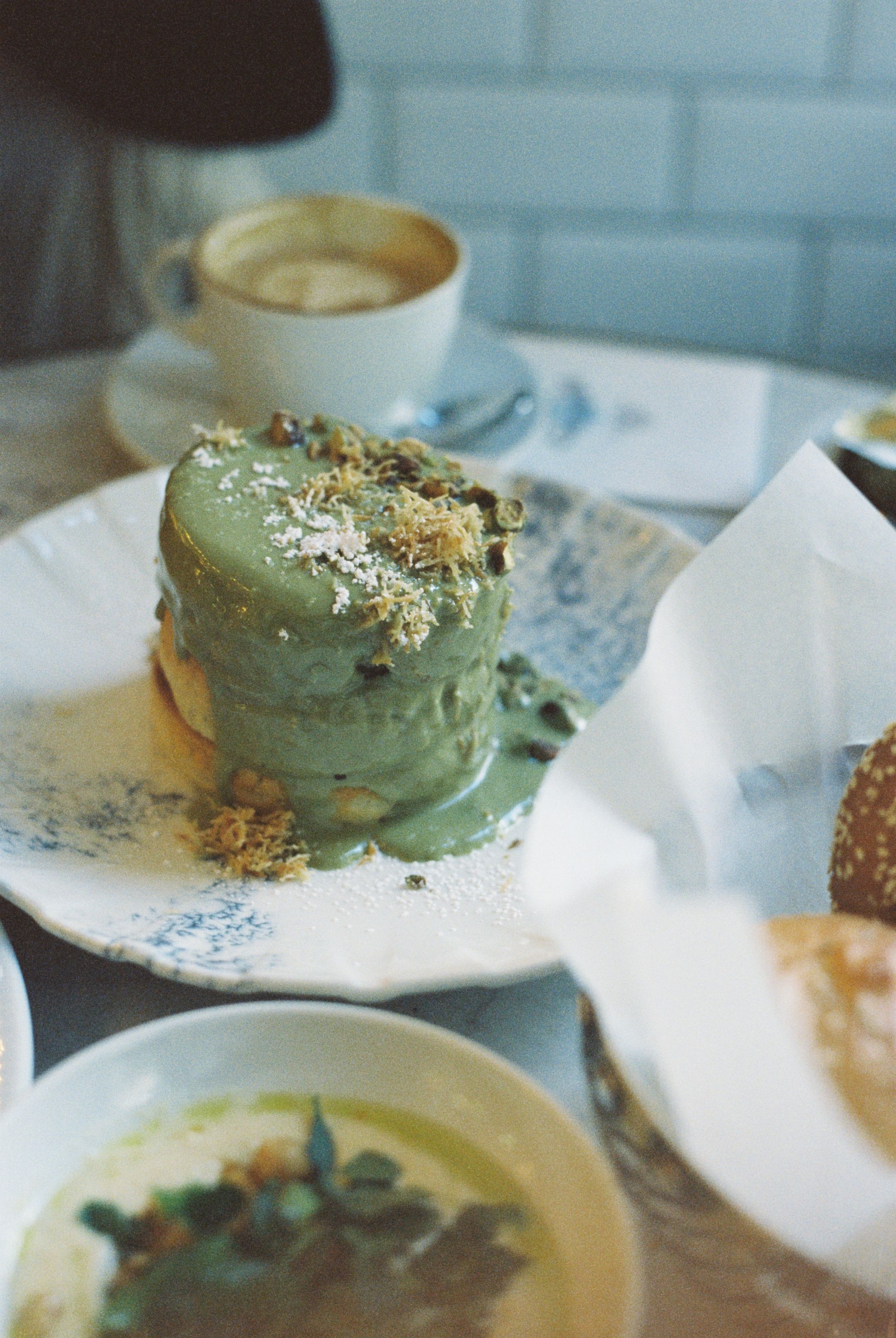 Stack of fluffy pancakes with pistachio cream in a cozy café setting. Perfect for breakfast lovers.