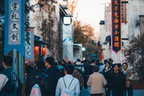 Free View of people walking along a vibrant, busy market street in an Asian city. Stock Photo