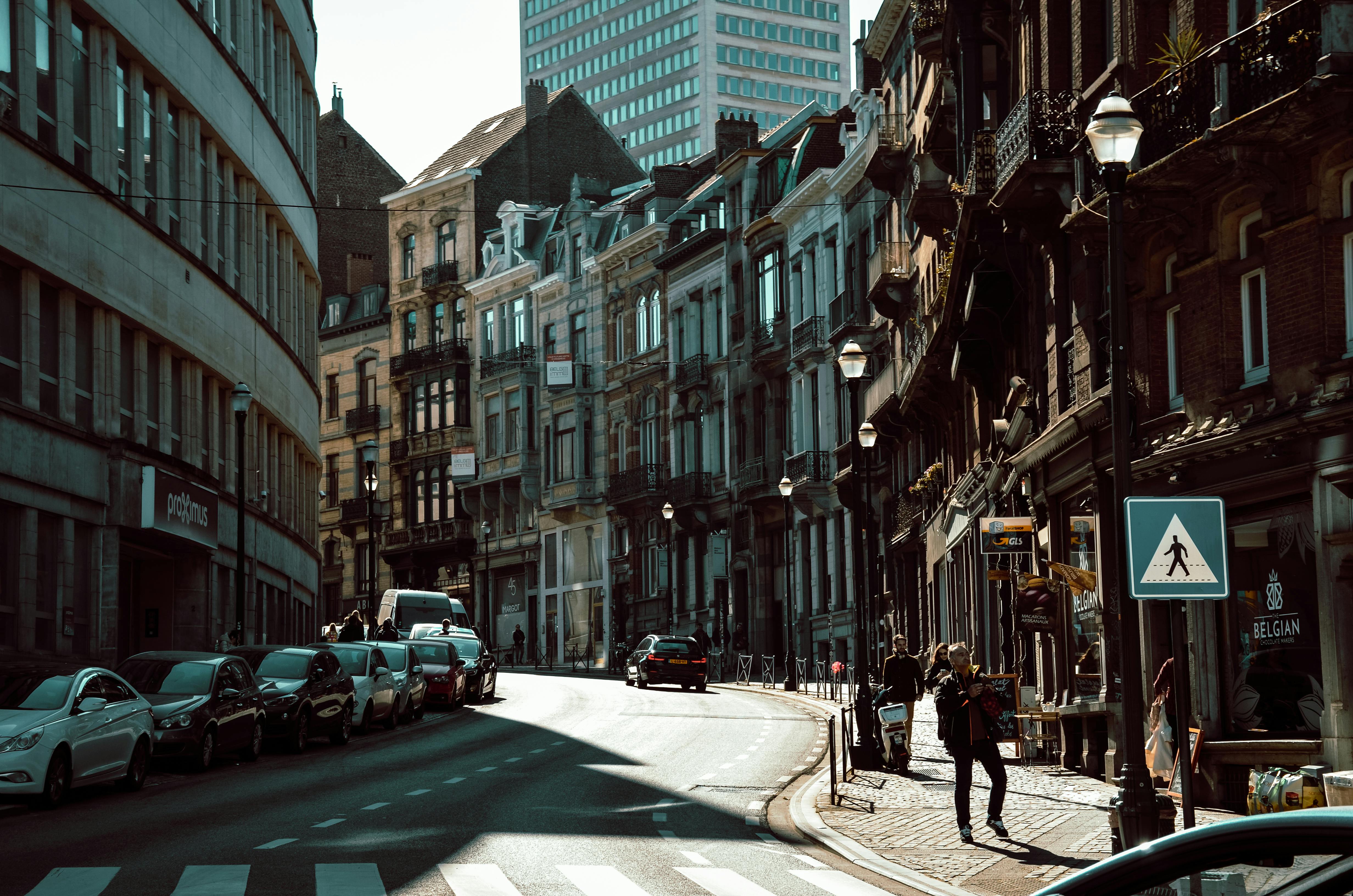 Belçika'da günlük yaşamı, yerel kültürü ve toplumsal uyumu temsil eden, sokakta vakit geçiren insanlar ve Belçika mimarisi.