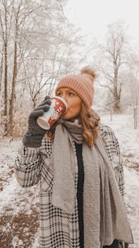 Woman enjoying a warm drink in a snowy Cheadle forest, capturing the essence of winter.