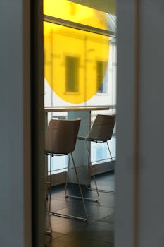 Contemporary seating area with a bright yellow window, capturing urban architecture.